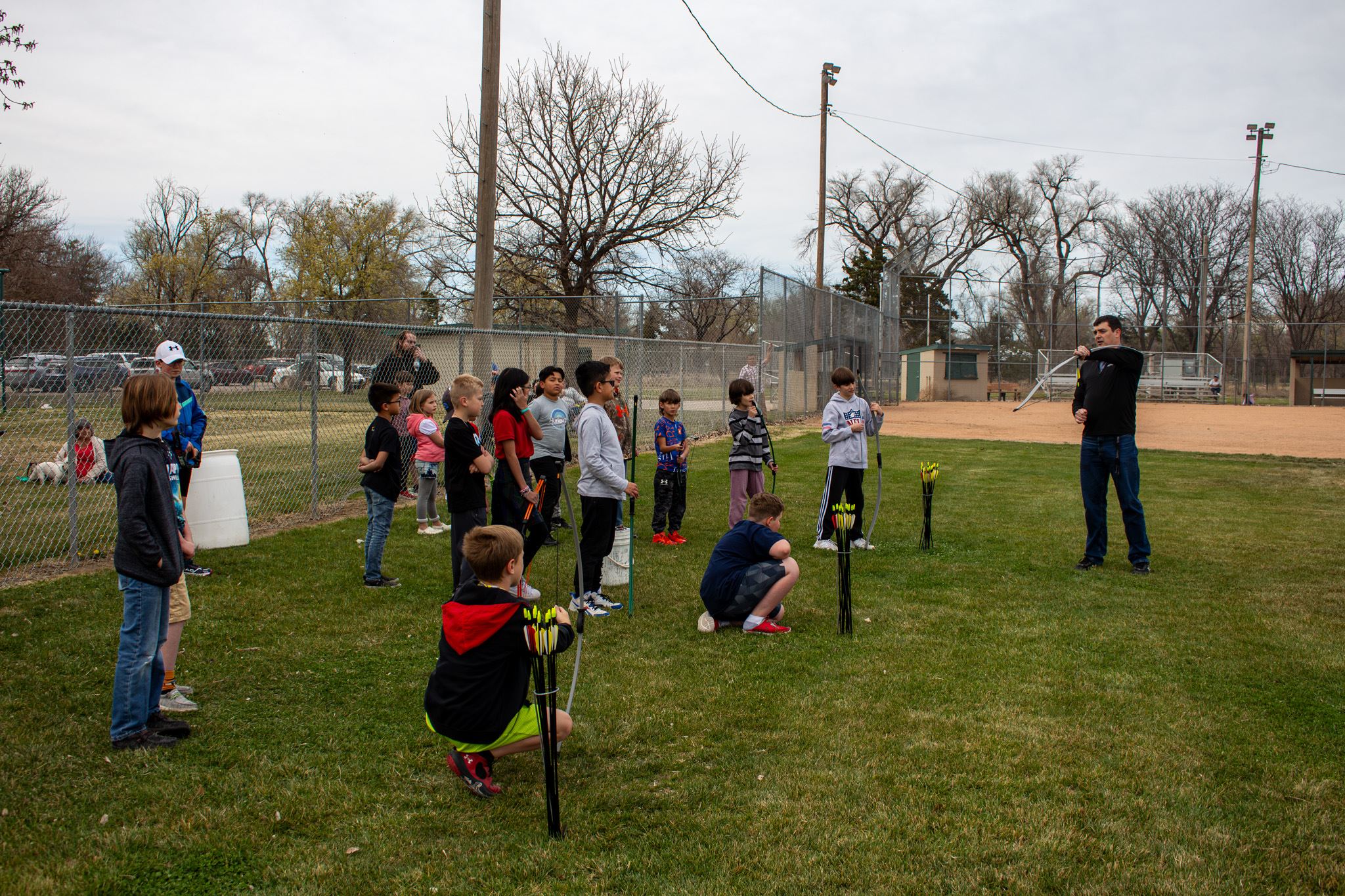 Parks and Recreation Instructor teaching a group of 20 kids between 8 - 12 years old archery